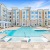 resort-inspired swimming pool surrounded by white lounge chairs and private cabanas at Bainbridge Cary Apartments in NC